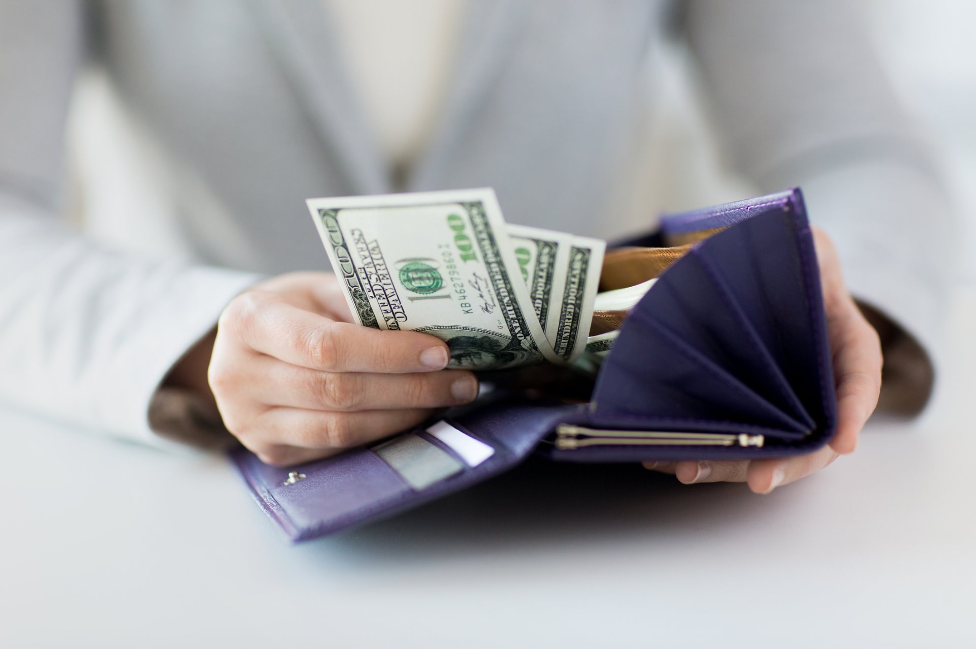 woman putting money in wallet